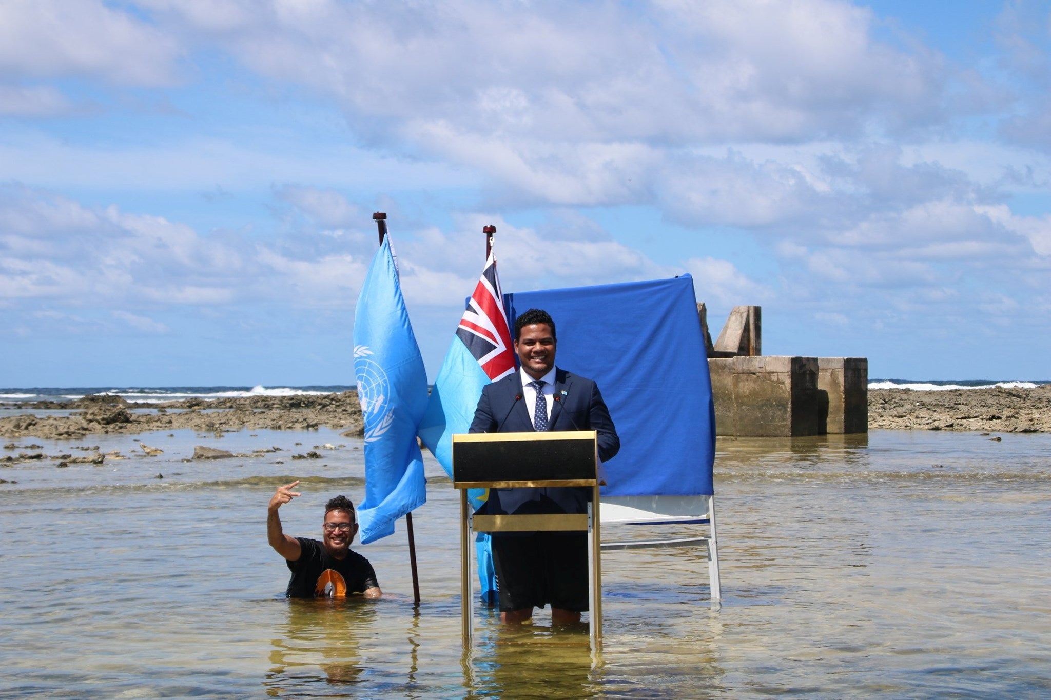 Tuvalu's Minister for Justice, Communication & Foreign Affairs Simon Kofe gives a COP26 statement while standing in the ocean