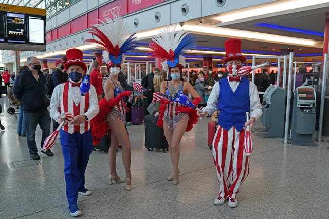 Performers entertain passengers at London Heathrow Airport’s T3 as the US reopens its borders to UK visitors (Steve Parsons/PA)