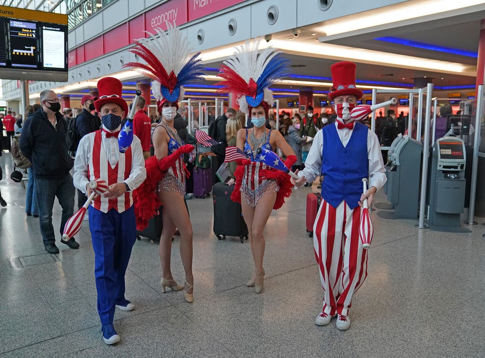Performers entertain passengers at London Heathrow Airport’s T3 as the US reopens its borders to UK visitors (Steve Parsons/PA)