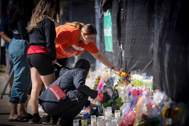 <p>People lay flowers and cards at a makeshift memorial for the victims of the Astroworld tragedy  </p>