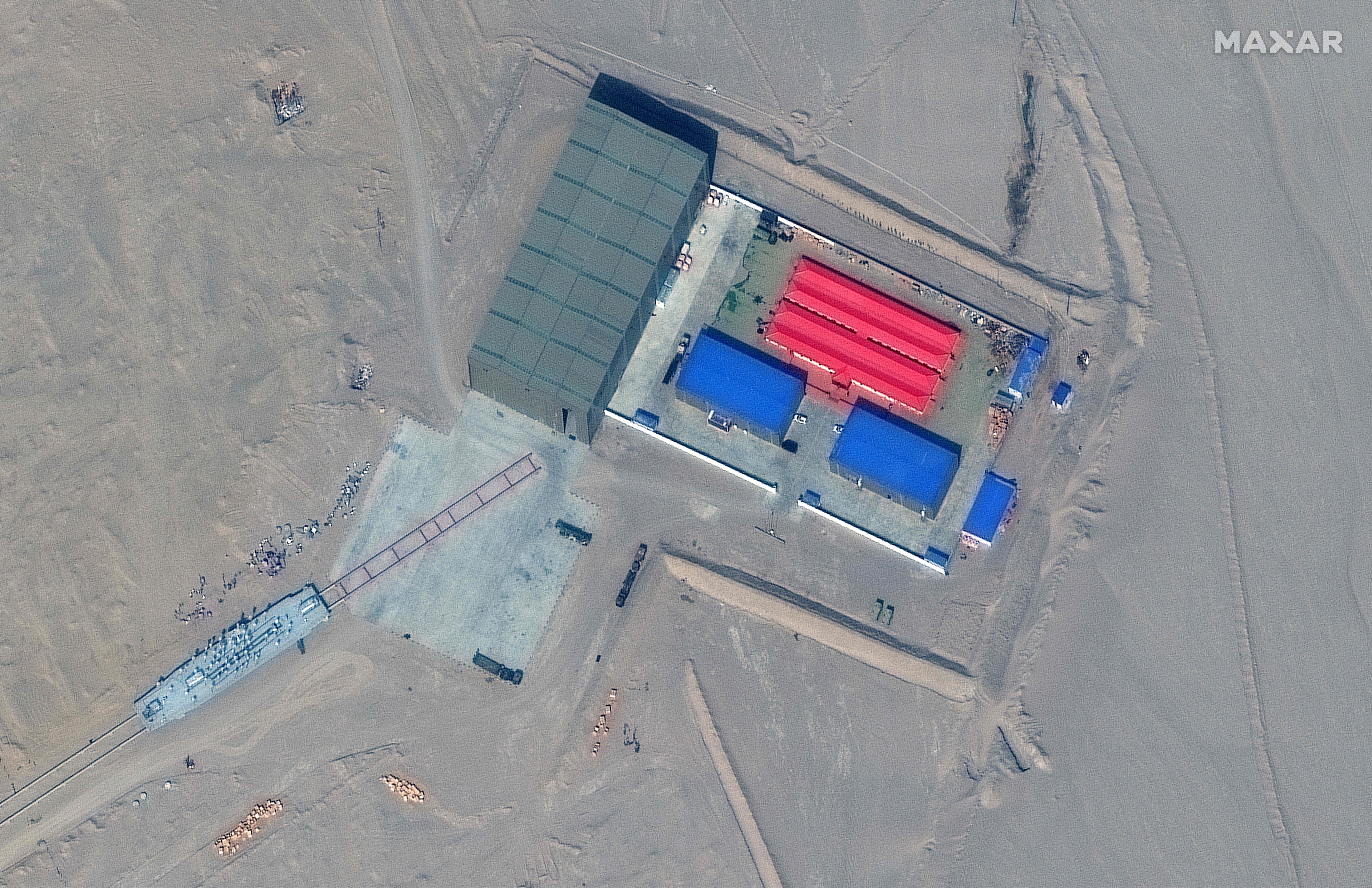 This handout satellite image released by Maxar Technologies on November 8, 2021 shows a rail terminus and a target storage building in Ruoqiang county in the Taklamakan Desert, China's western Xinjiang region on October 8, 2021