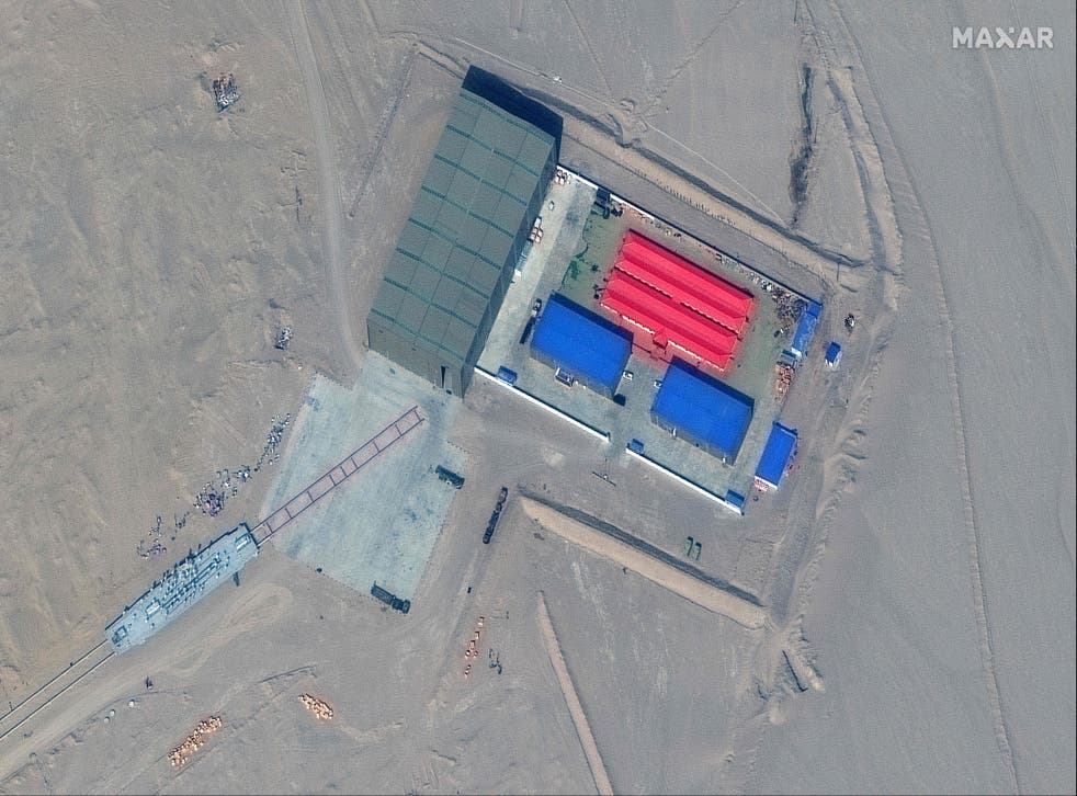 <p>This handout satellite image released by Maxar Technologies on November 8, 2021 shows a rail terminus and a target storage building in Ruoqiang county in the Taklamakan Desert, China's western Xinjiang region on October 8, 2021</p>