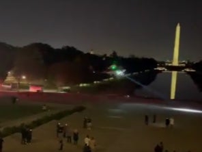 A helicopter lands at Lincoln memorial as stunned onlookers capture videos and photos
