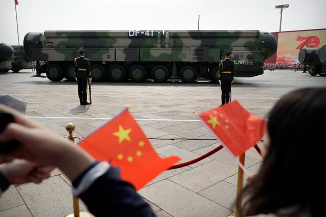 <p>Spectators wave Chinese flags during a parade in Beijing </p>