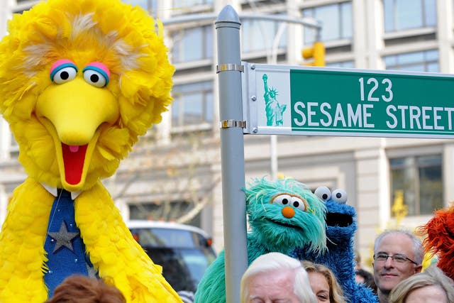 <p>Big Bird and other Sesame Street puppet characters post net to a temporary street sign on 9 November 2009 in New York City</p>