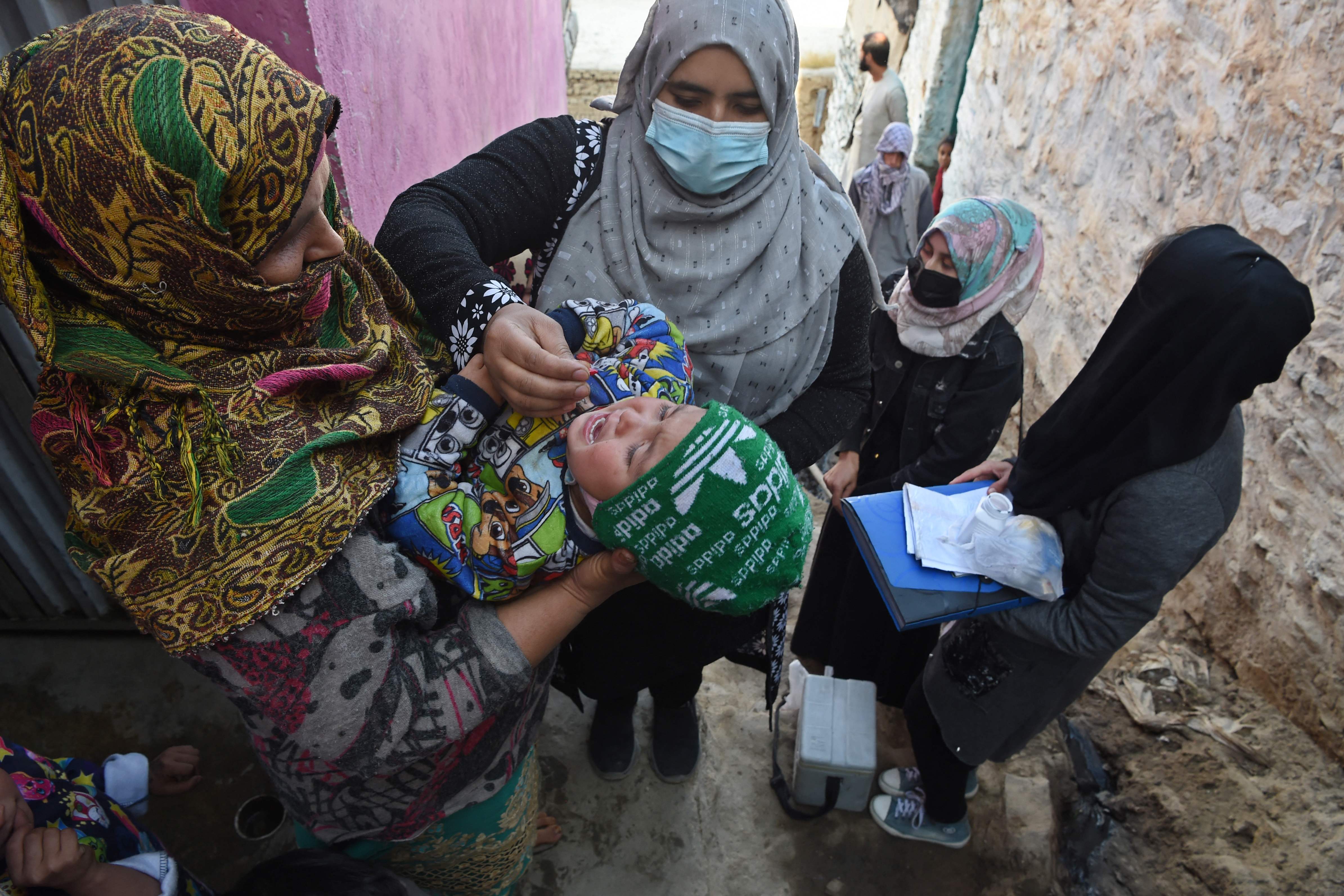 A health worker administers polio vaccine drops to a child in Kabul