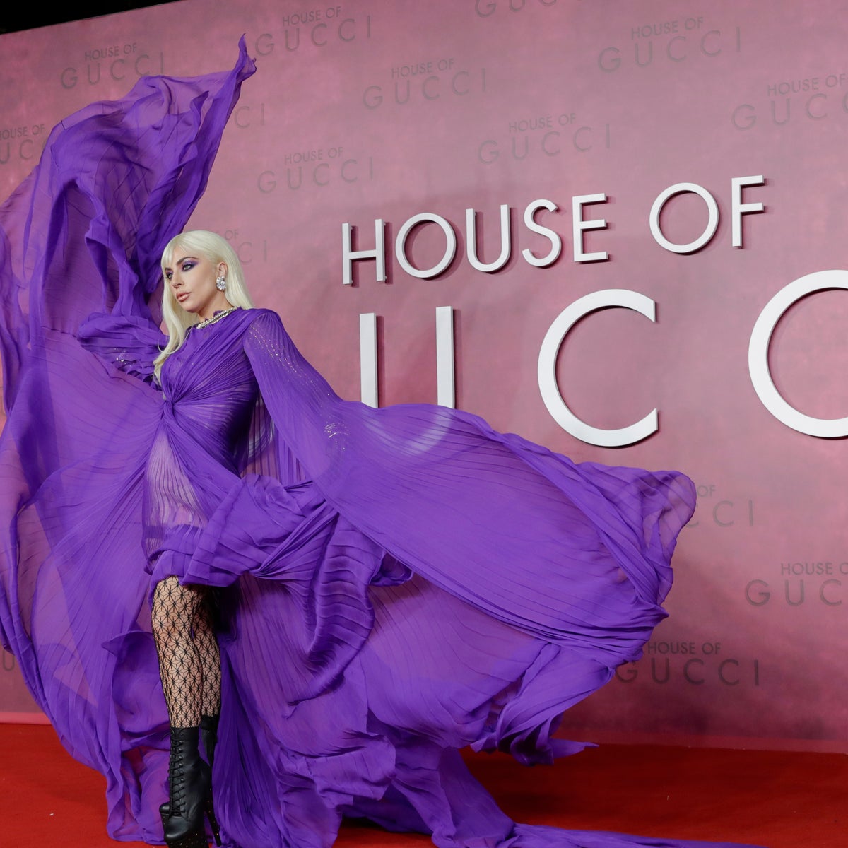lady gaga purple gucci dress Lady Gaga made jaws drop at the House of Gucci premiere in this sheer, pleated purple gown with statement sleeves and glittering fishnet tights