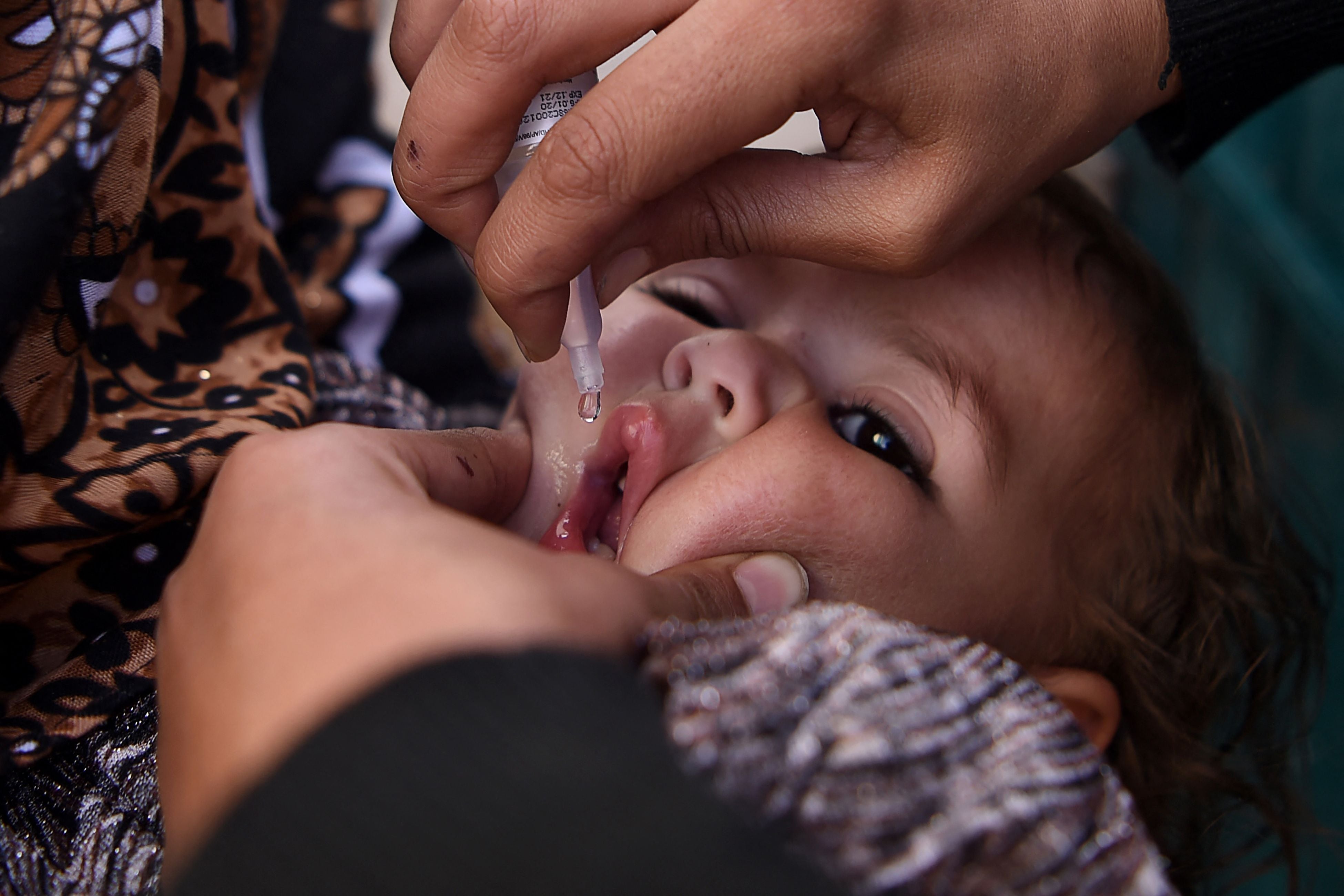 A health worker administers polio vaccine drops to a child during a vaccination campaign in the old quarters of Kabul on Monday