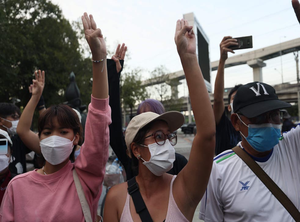 <p>Protesters hold up the three finger salute outside the Constitutional Court of Thailand in Bangkok</p>