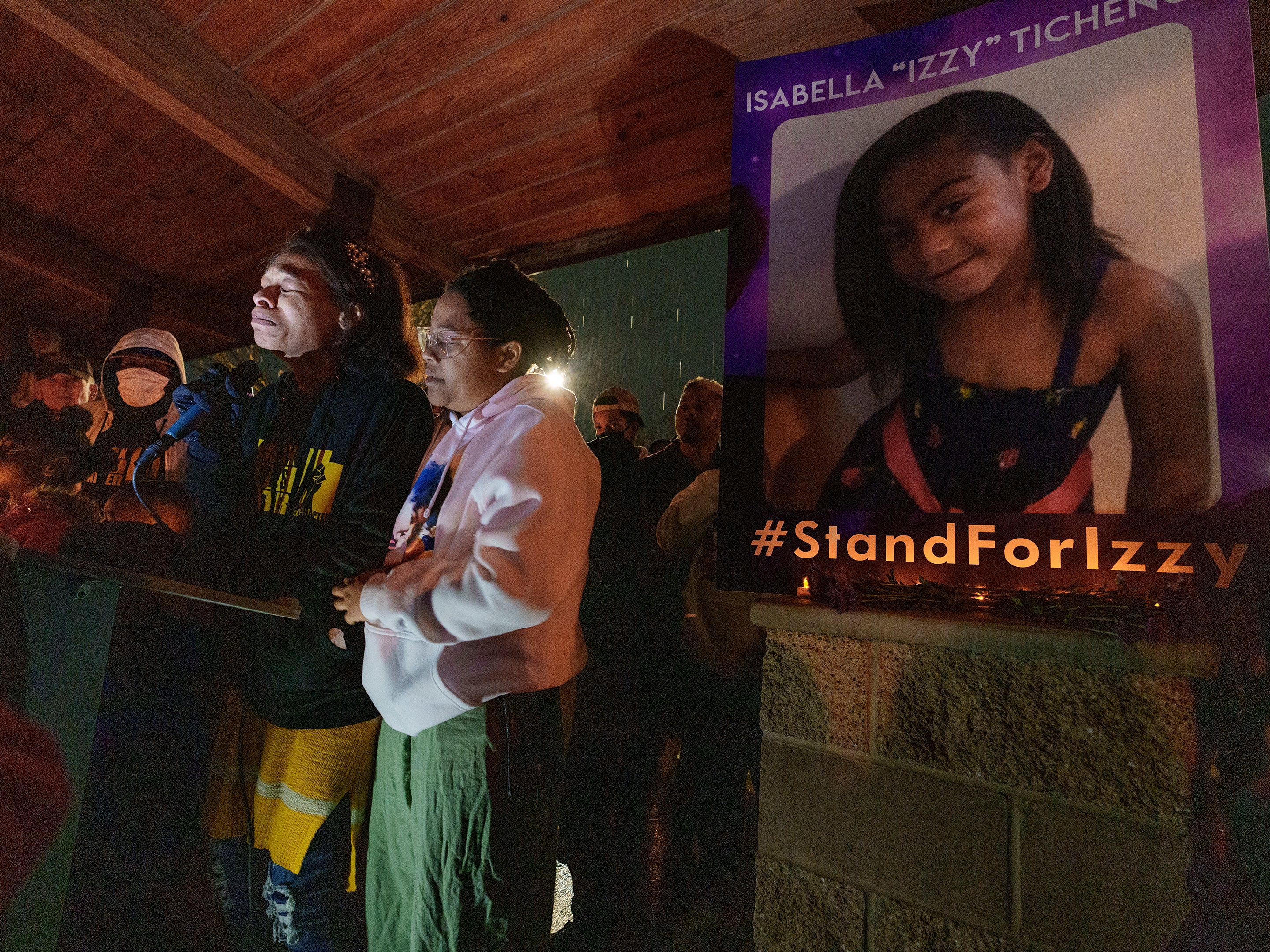Brittany Tichenor- Cox joined by her sister Jasmine Rhodes, right, speaks about her daughter Izzy Tichenor, as hundreds joined the Tichenor family in mourning the death of 10-year-old Isabella "Izzy" Tichenor during a vigil at Foxboro Hollow Park in North Salt Lake, Utah, on Tuesday, 9 November 2021