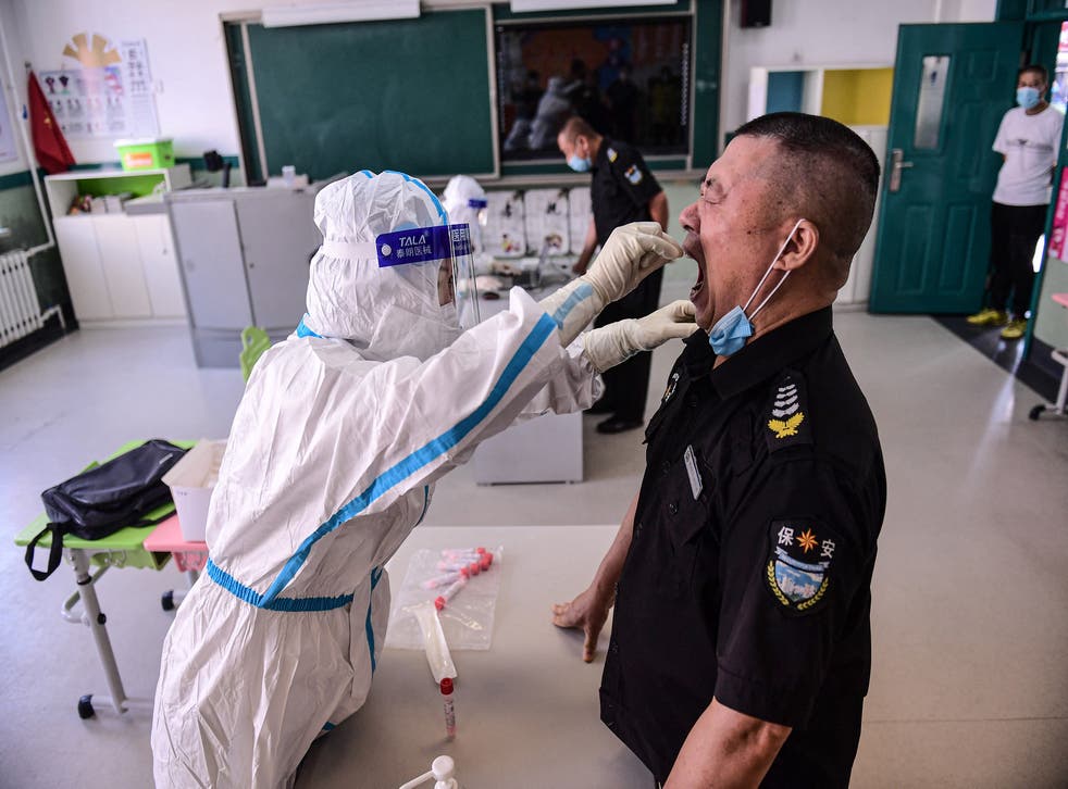 <p>File: A primary school staff member undergoes a nucleic acid test to detect the novel coronavirus ahead of the new semester at a school in Shenyang in China’s northeastern Liaoning province on 30 August 2021</p>