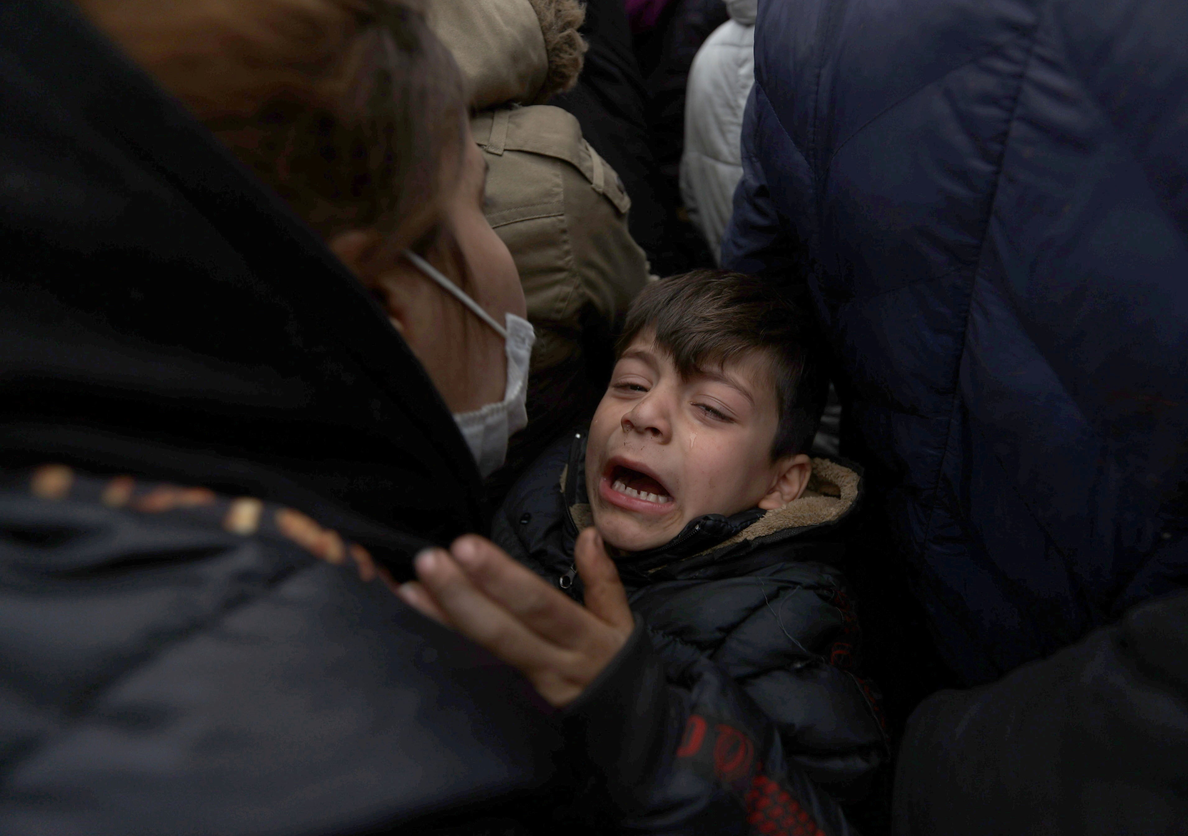 A child is in distress as migrants gather on the Belarusian-Polish border on Thursday