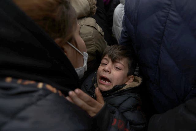 <p>A child is in distress as migrants gather on the Belarusian-Polish border on Thursday </p>