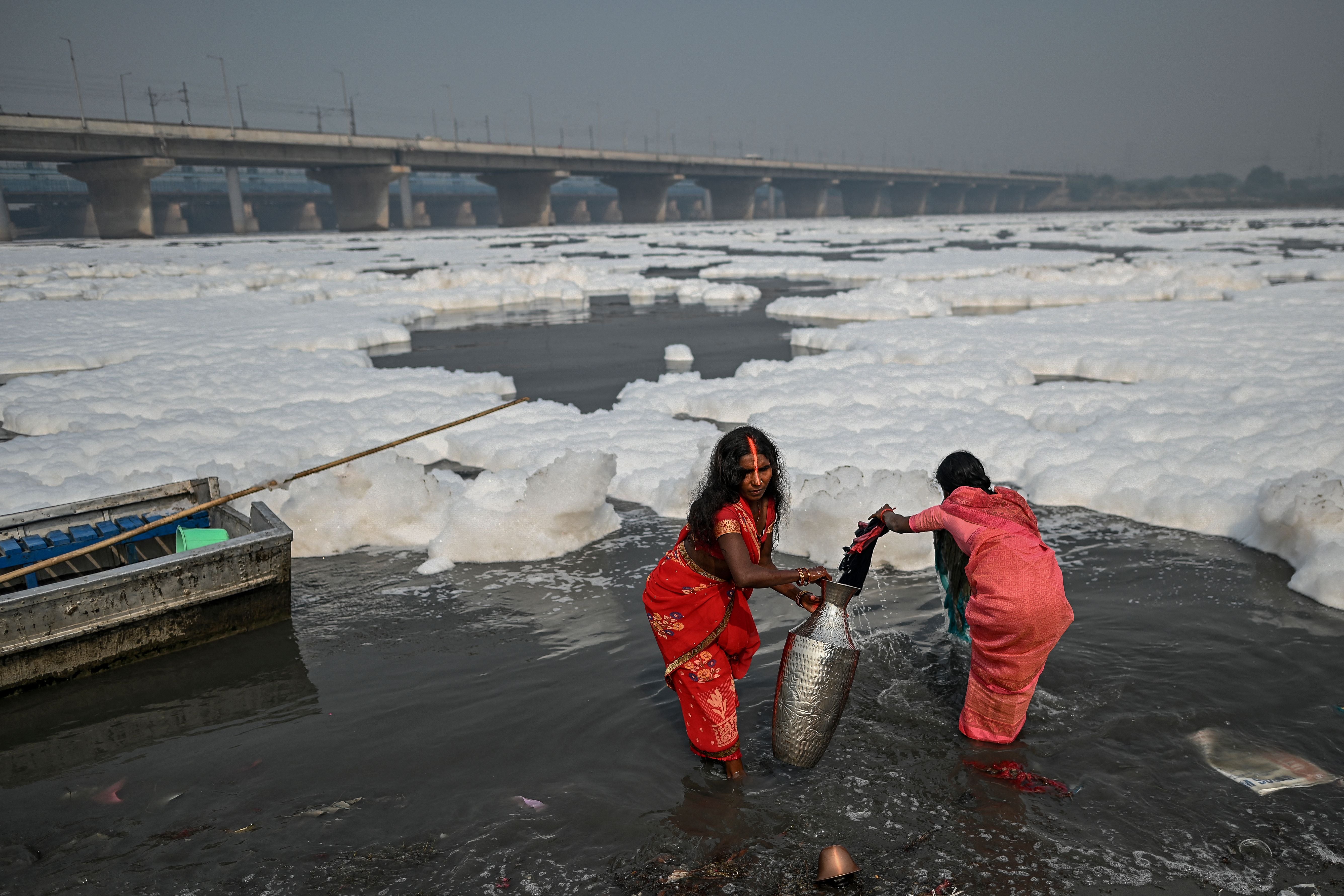 Women take a dip in the Yamuna river as part of rituals for Chhath