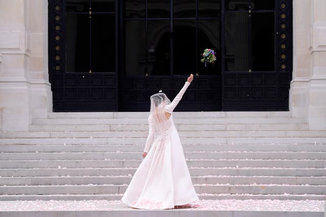 <p>Lucky for some: Qualley, in a Chanel wedding dress, tosses the bouquet during Paris Fashion Week </p>