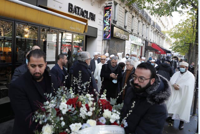 <p>People pay tribute to the victims of the 2015 attacks outside the Bataclan concert hall in Paris on 12 November 2021 </p>