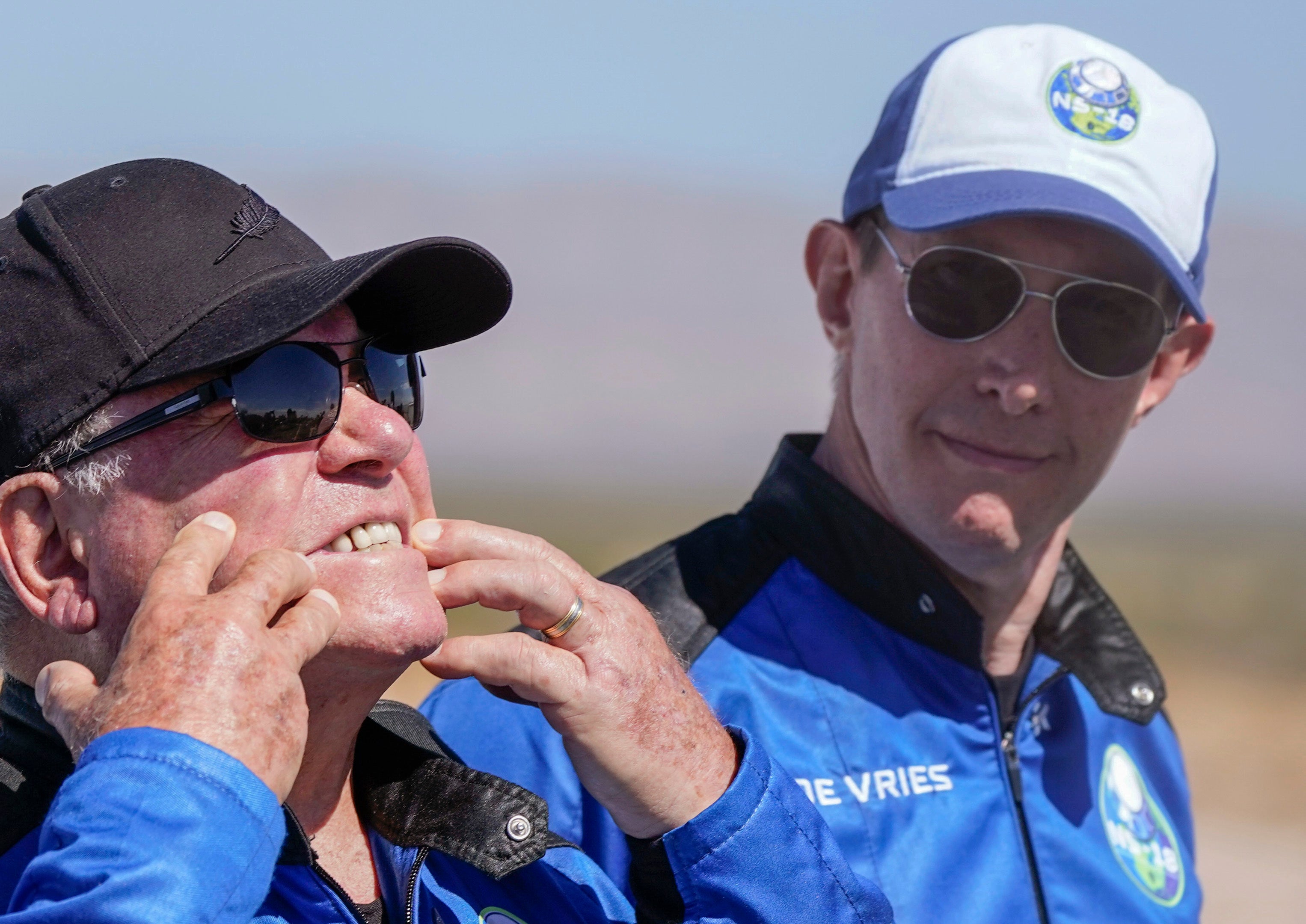 Glen de Vries, right, takes a look as William Shatner, left, shows what rocket lift off did to his face during a media availability at the spaceport near Van Horn, Texas, Wednesday, Oct. 13, 2021