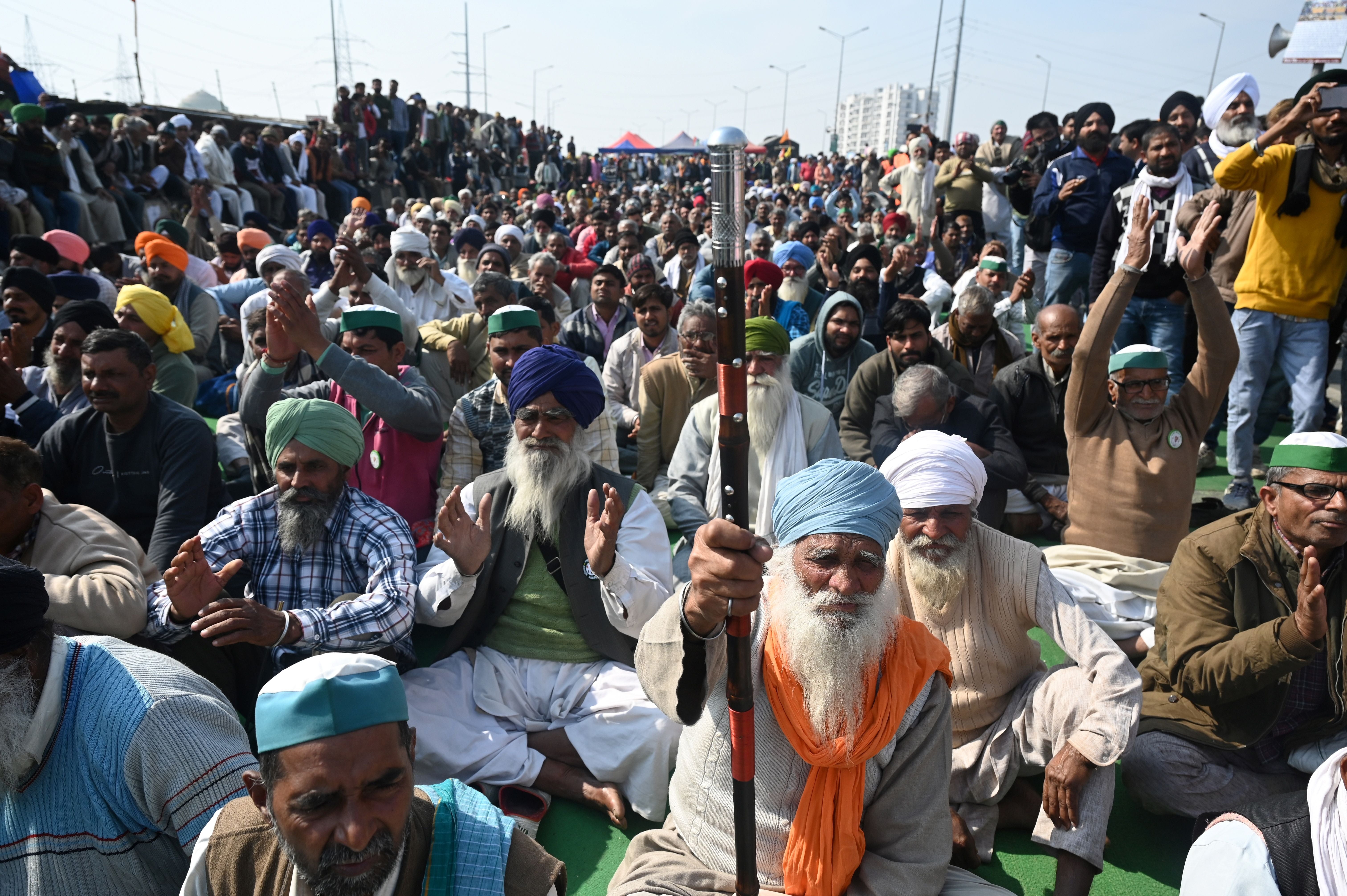 Farmers sit along a blocked highway during a protest against the central government’s recent agricultural reforms at the Delhi-Uttar Pradesh state border