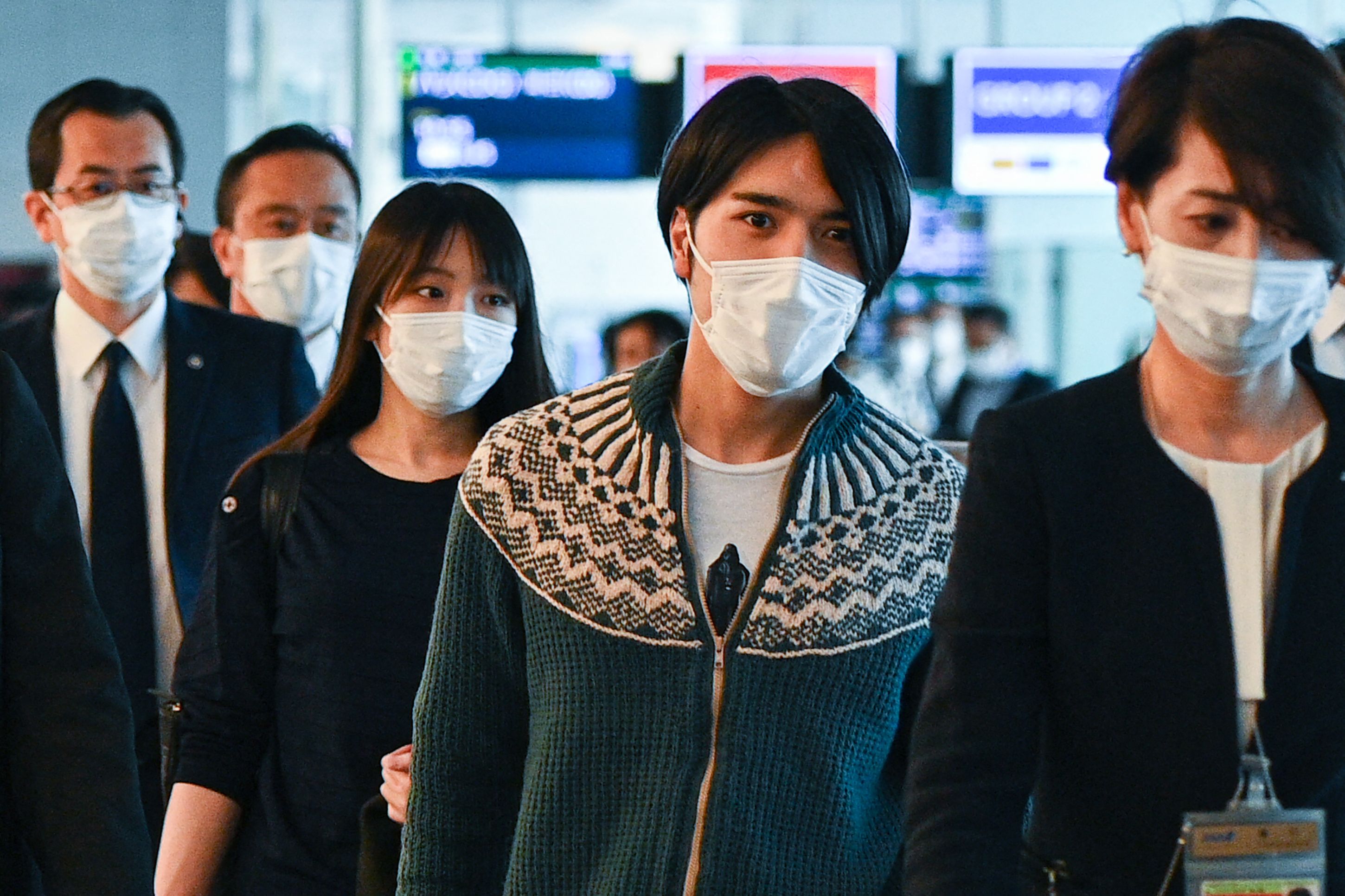 Japan’s former princess Mako Komuro and her husband Kei Komuro (second from right) walk to the departure gate for their flight to New York