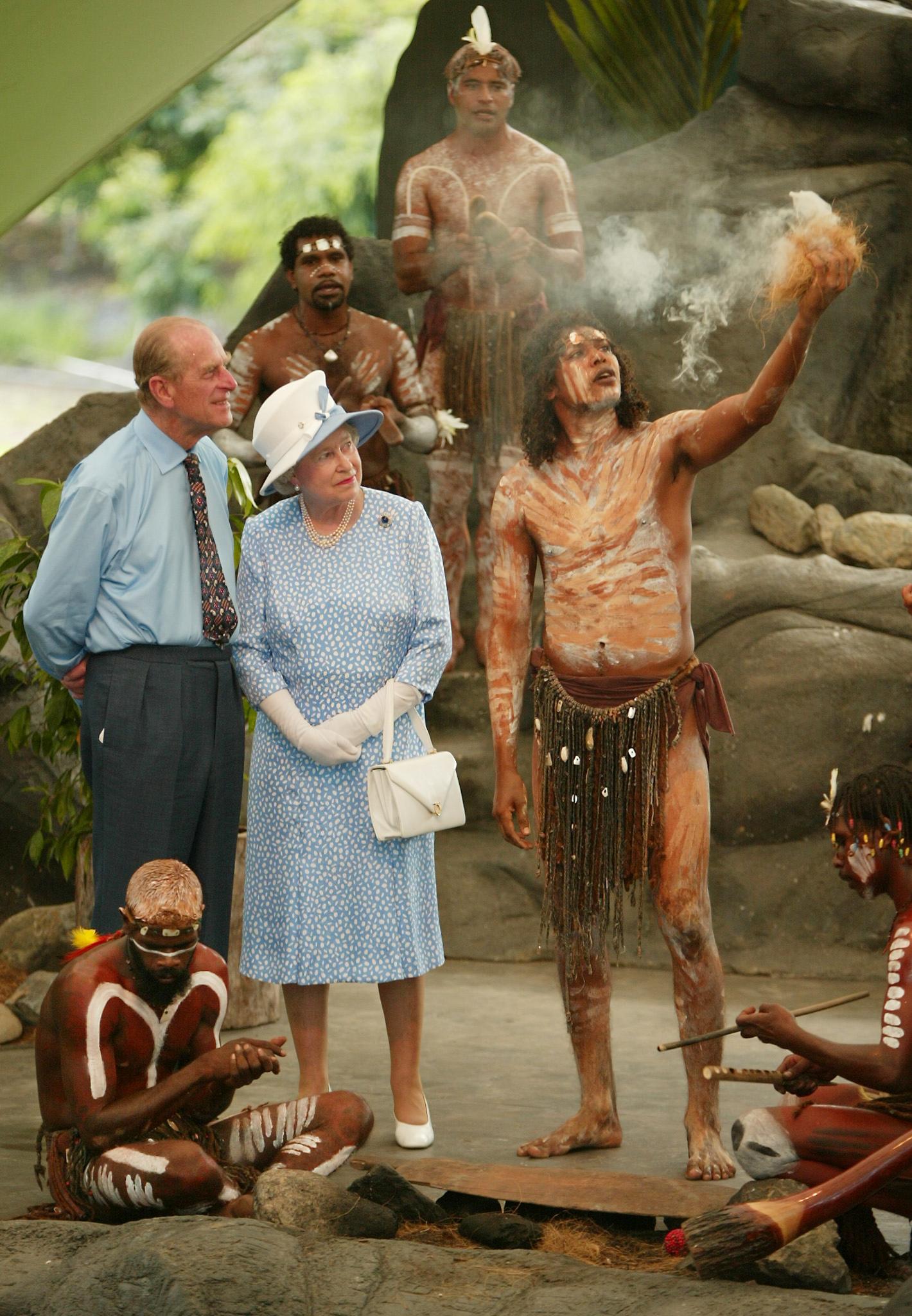 Queen Elizabeth II and Philip watch Tjapukai Aborigines light a ceremonial fire near Cairns, Australia in 2002 on the final leg of her golden jubilee tour
