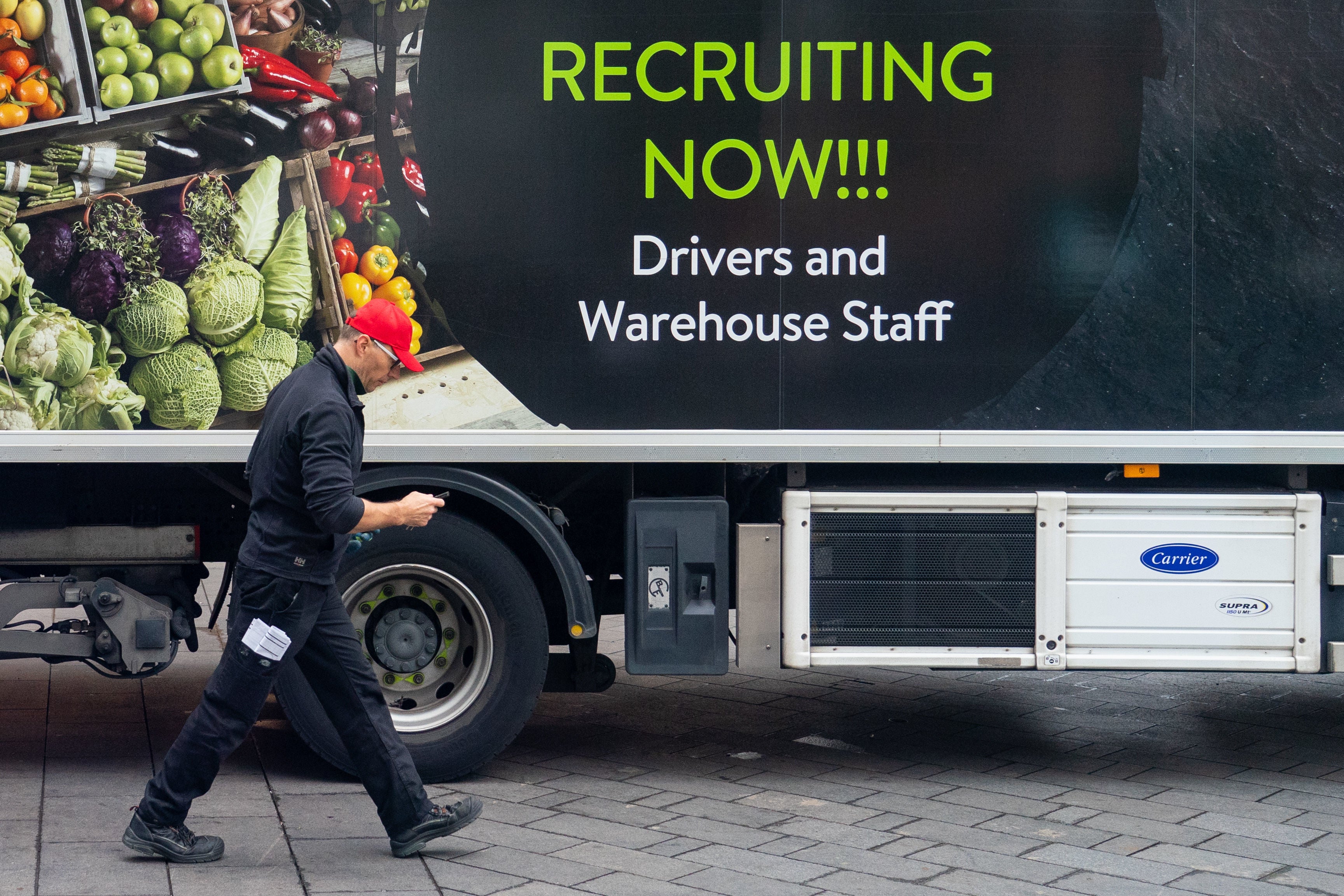 An advert for drivers and warehouse staff on the side of a lorry