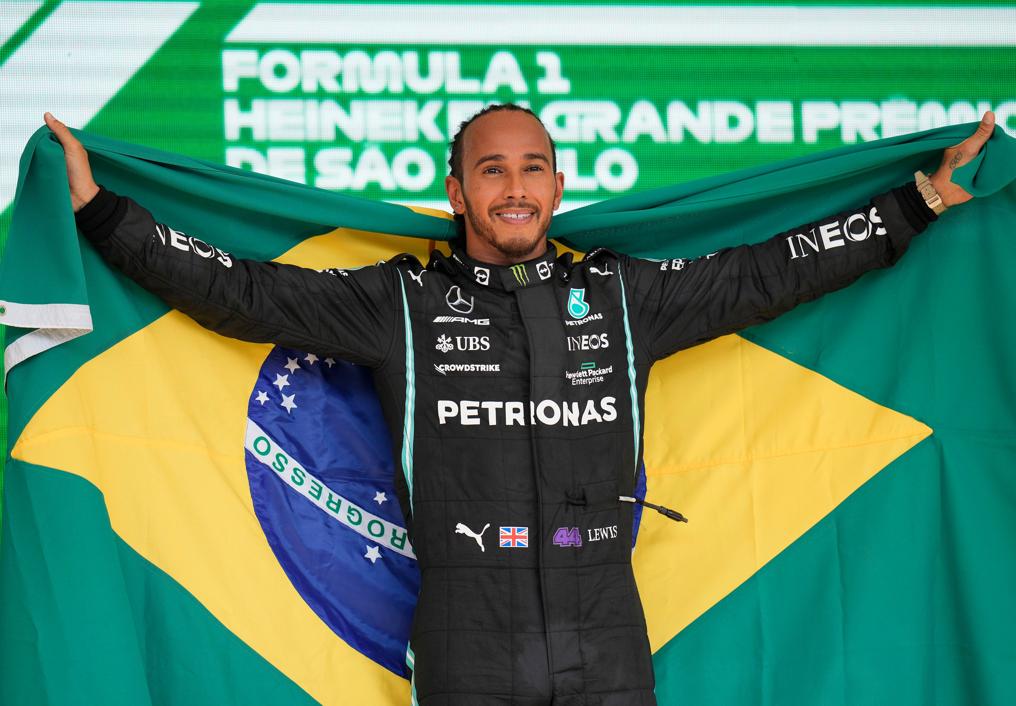 Lewis Hamilton holds a Brazilian flag after his victory (Andre Penner/AP)