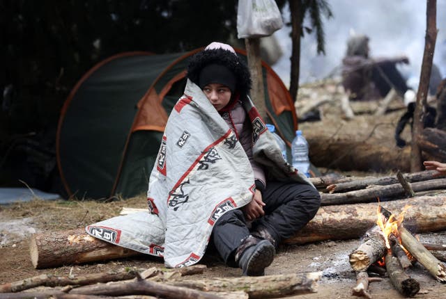 <p>File: A migrant sits in front of a fire in a camp near the Belarusian-Polish border </p>