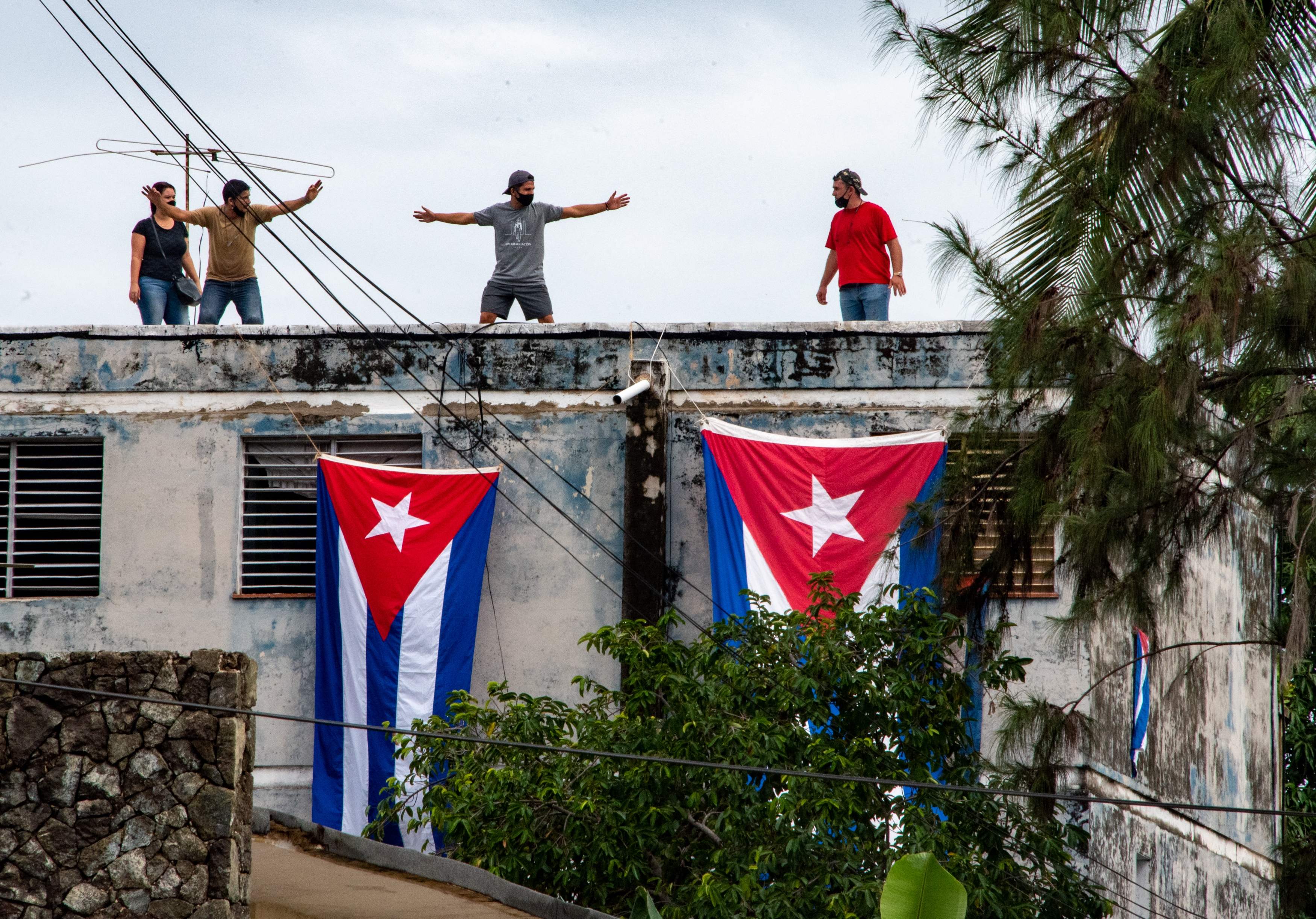 Pro-government protesters cover the apartment of Yunior Garcia, the organizer of Monday’s marches, with Cuban flags in Havana on 14 November
