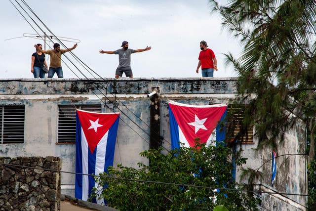 <p>Pro-government protesters cover the apartment of Yunior Garcia, the organizer of Monday’s marches, with Cuban flags in Havana on 14 November</p>