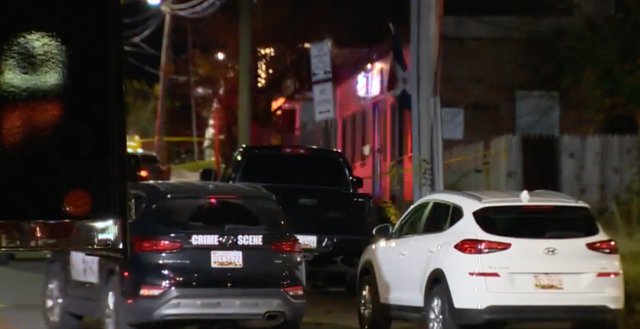 <p>Police vehicles outside a barber shop in Baltimore where an off-duty police officer shot and killed a gunman who had burst in and shot one of the barbers</p>