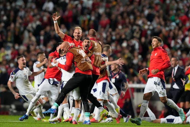 Serbia celebrate victory in Portugal, which sealed their place at Qatar 2022 (Armando Franca/AP)