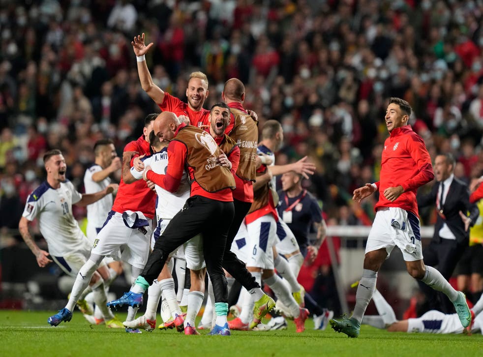 Serbia celebrate victory in Portugal, which sealed their place at Qatar 2022 (Armando Franca/AP)