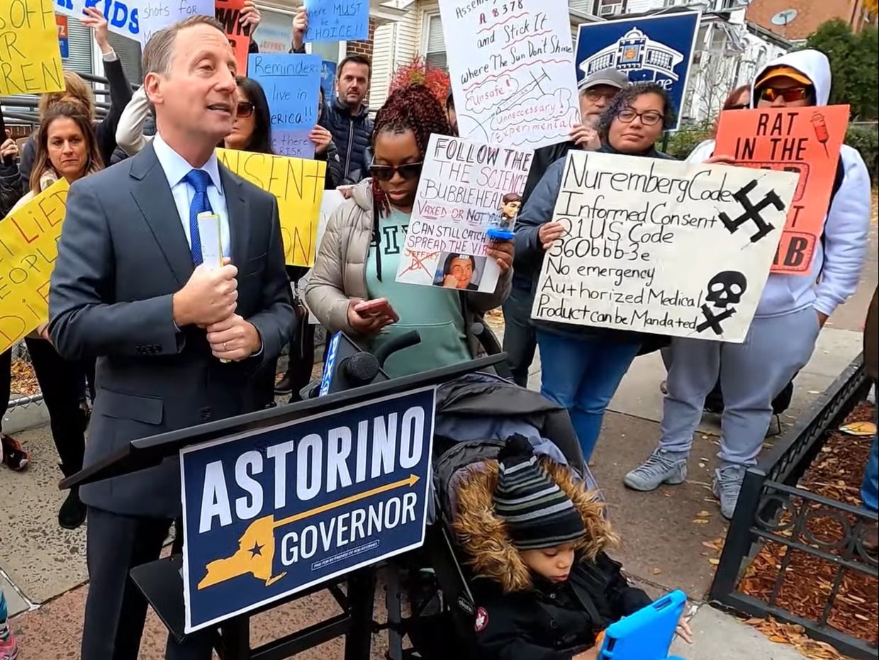 <p>Rob Astorino, a Republican politician, speaks just feet away from a woman holding a swastika sign, who he later claimed he had not noticed </p>