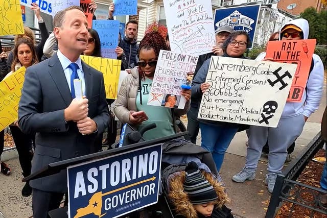 <p>Rob Astorino, a Republican politician, speaks just feet away from a woman holding a swastika sign, who he later claimed he had not noticed </p>