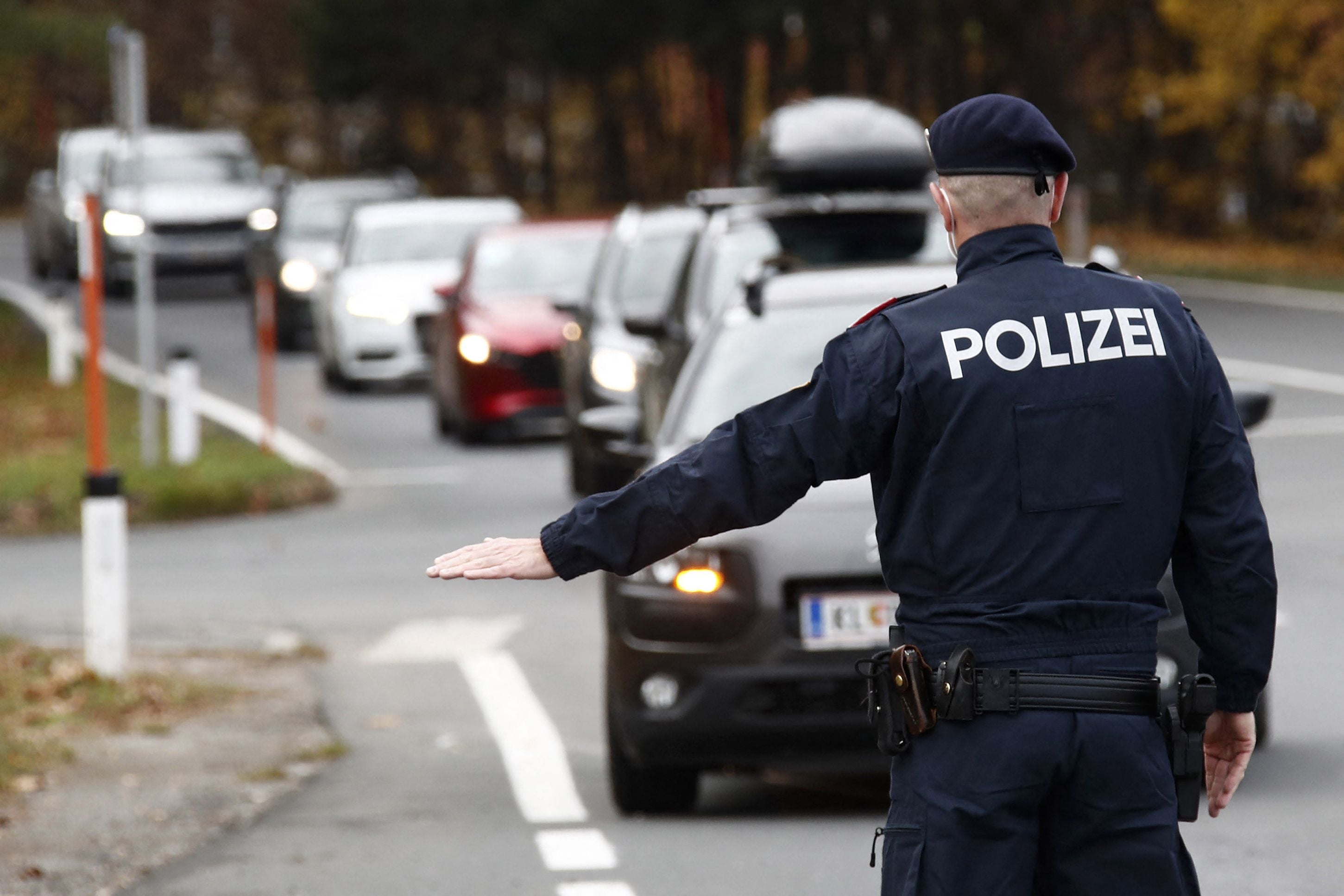 Austrian police officer checks cars during first day of lockdown for the unvaccinated