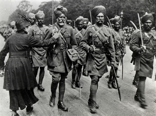 A woman pins a flower on the uniform of Ganga Dat Singh, a Hindu risaldar-major, during the 1916 Bastille Day parade in Paris
