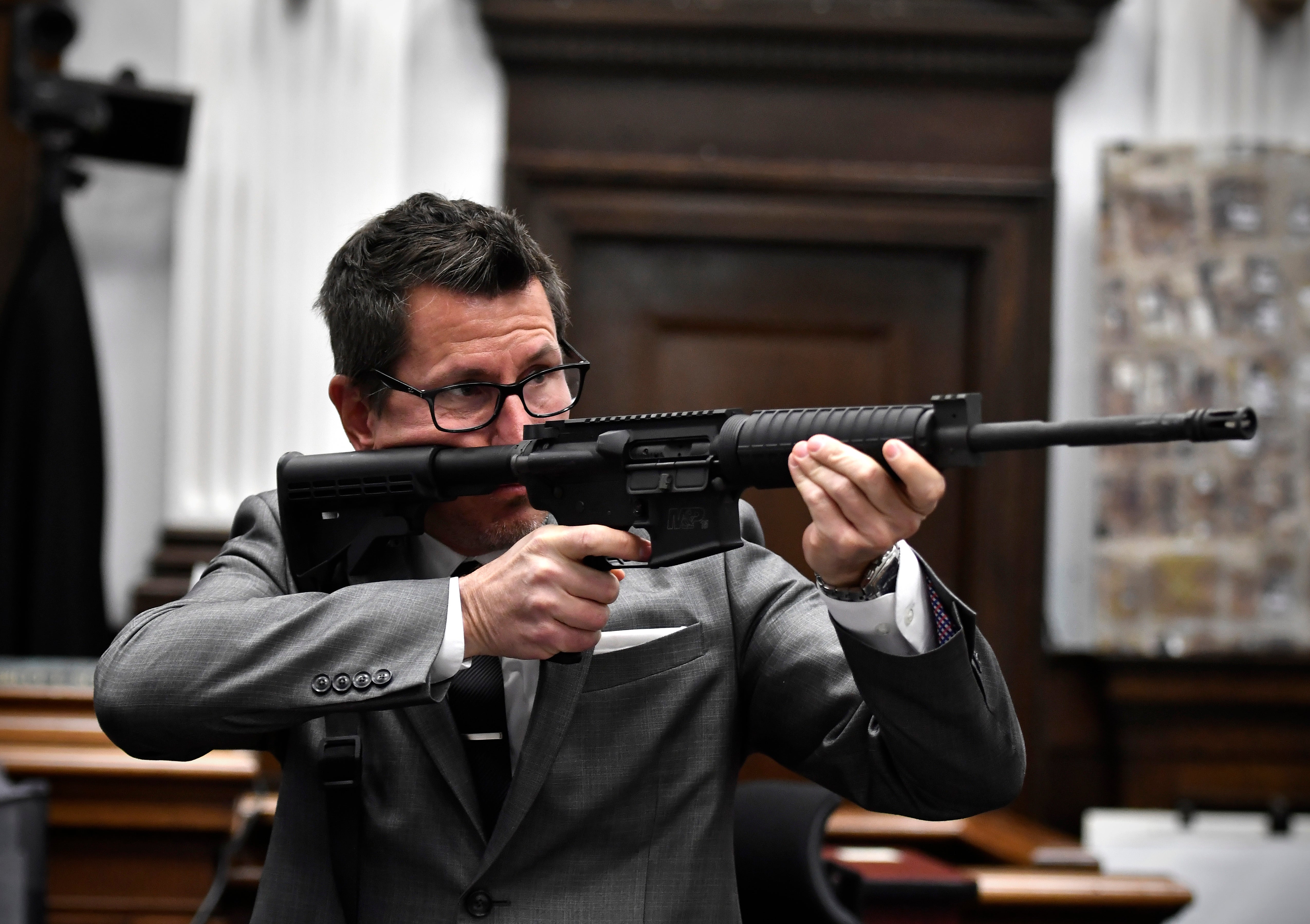 Prosecutor Mark Binger holds Kyle Rittenhouse’s rifle up in front of the jury during his closing argument on Monday