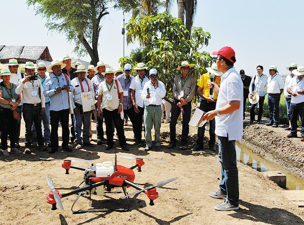 <p>Ma Zhiqiang explains the use of an agricultural drone to farmers in Ecuador</p>