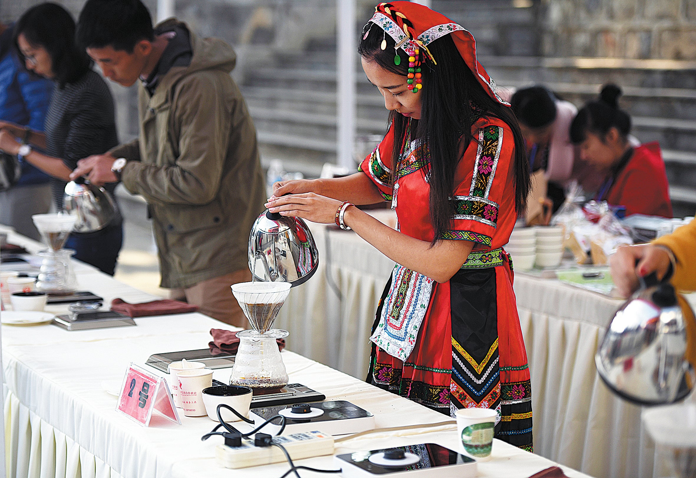 A woman makes coffee with freshly picked beans in Baoshan, Yunnan province