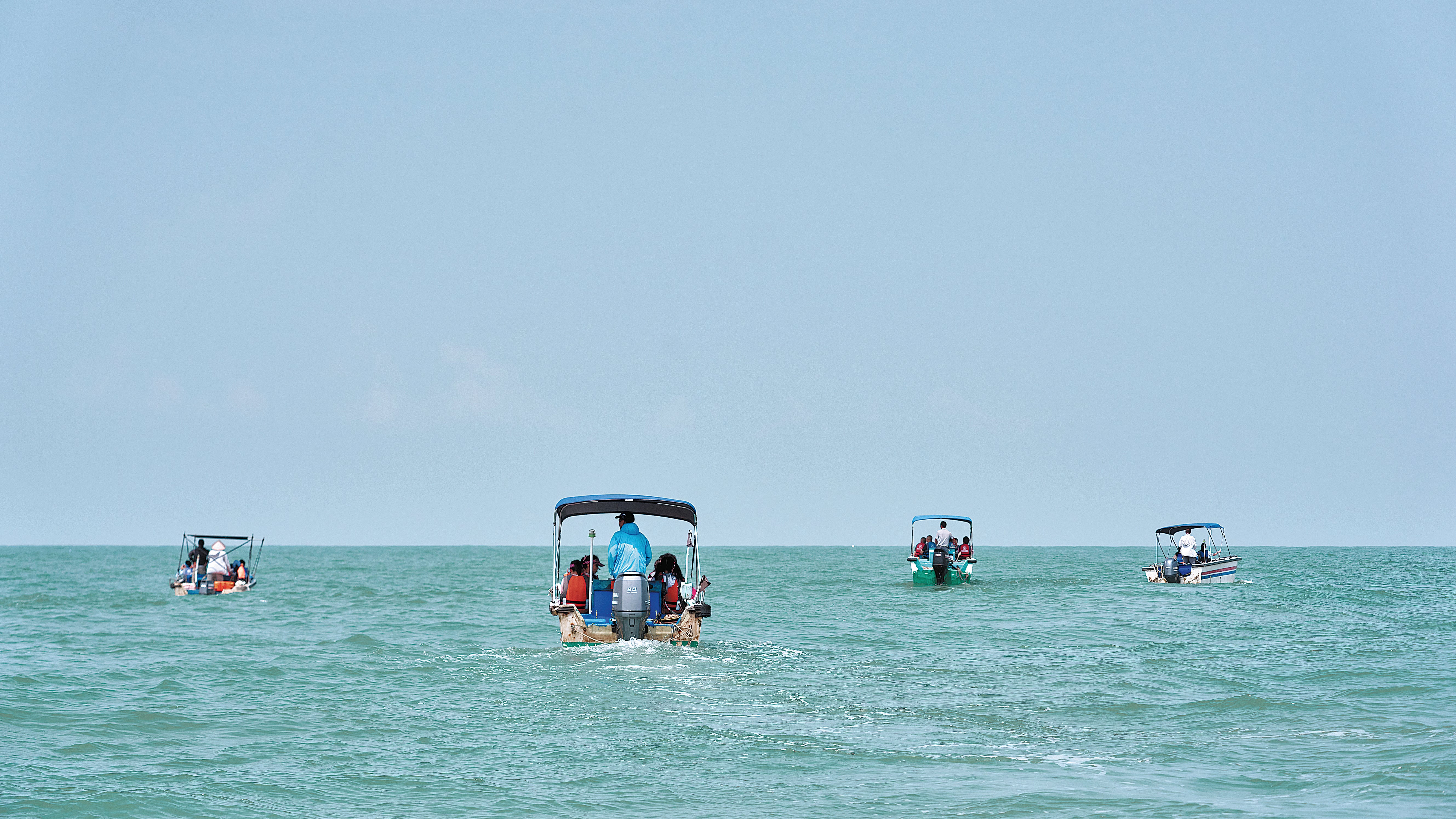 Students set out to sea in Sanniang Bay, Qinzhou, Guangxi Zhuang autonomous region, hoping to observe Chinese white dolphins