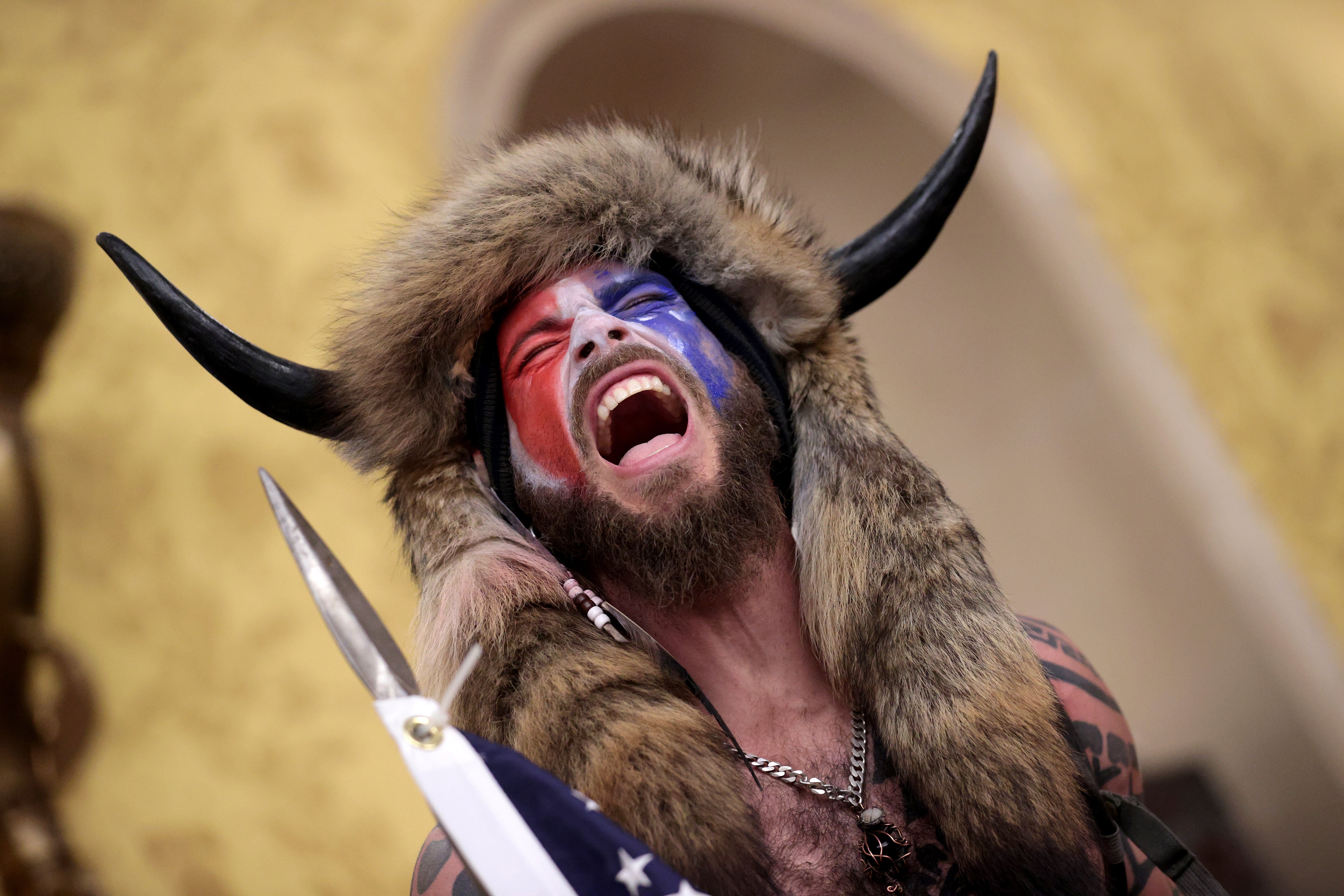 QAnon Shaman screams “Freedom” inside the Senate chamber on 6 January