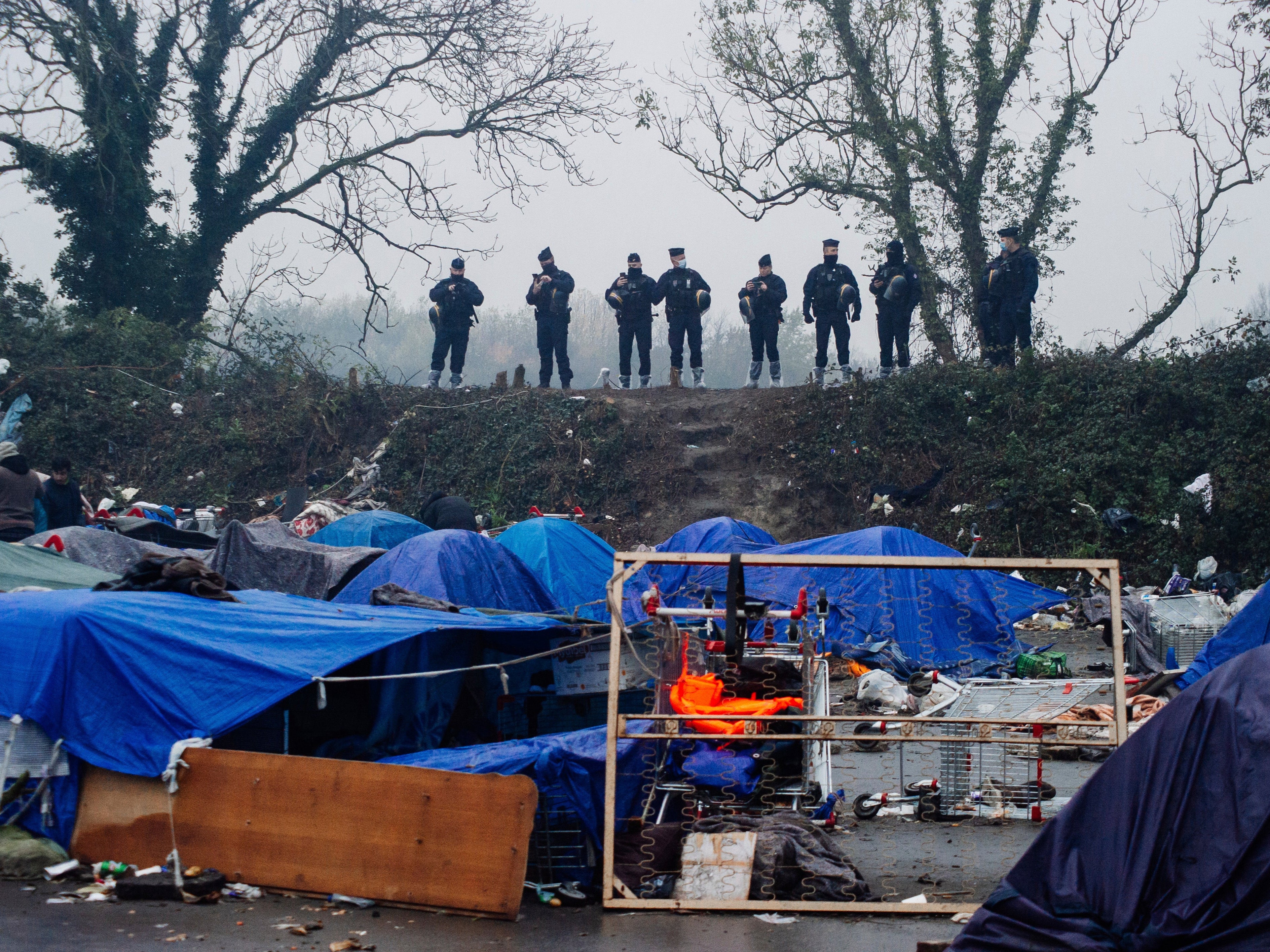 Police surround the makeshift camp in Grande-Synthe