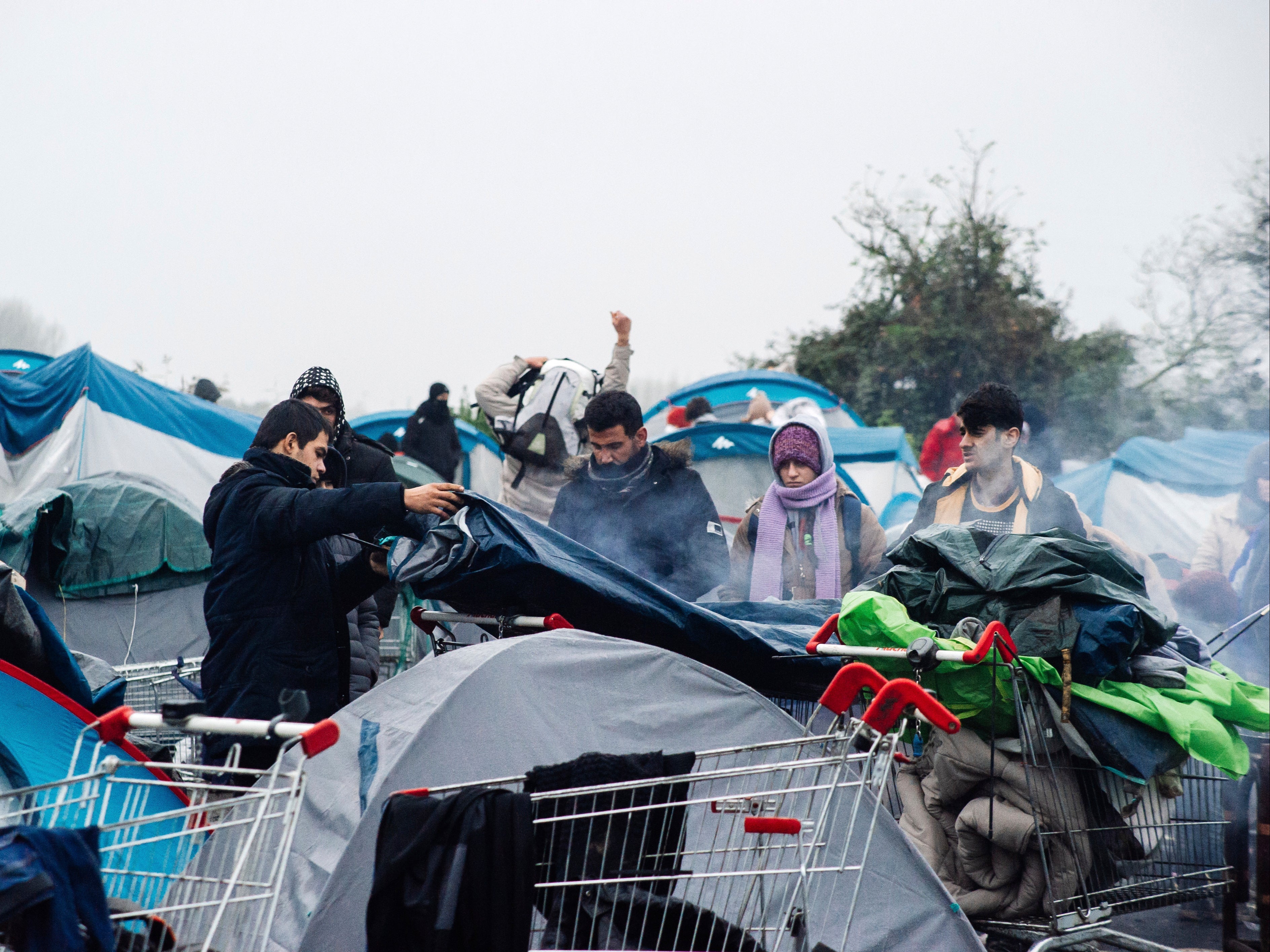 Migrants, including some families with young children, could be seen packing their few belongings early on Tuesday morning