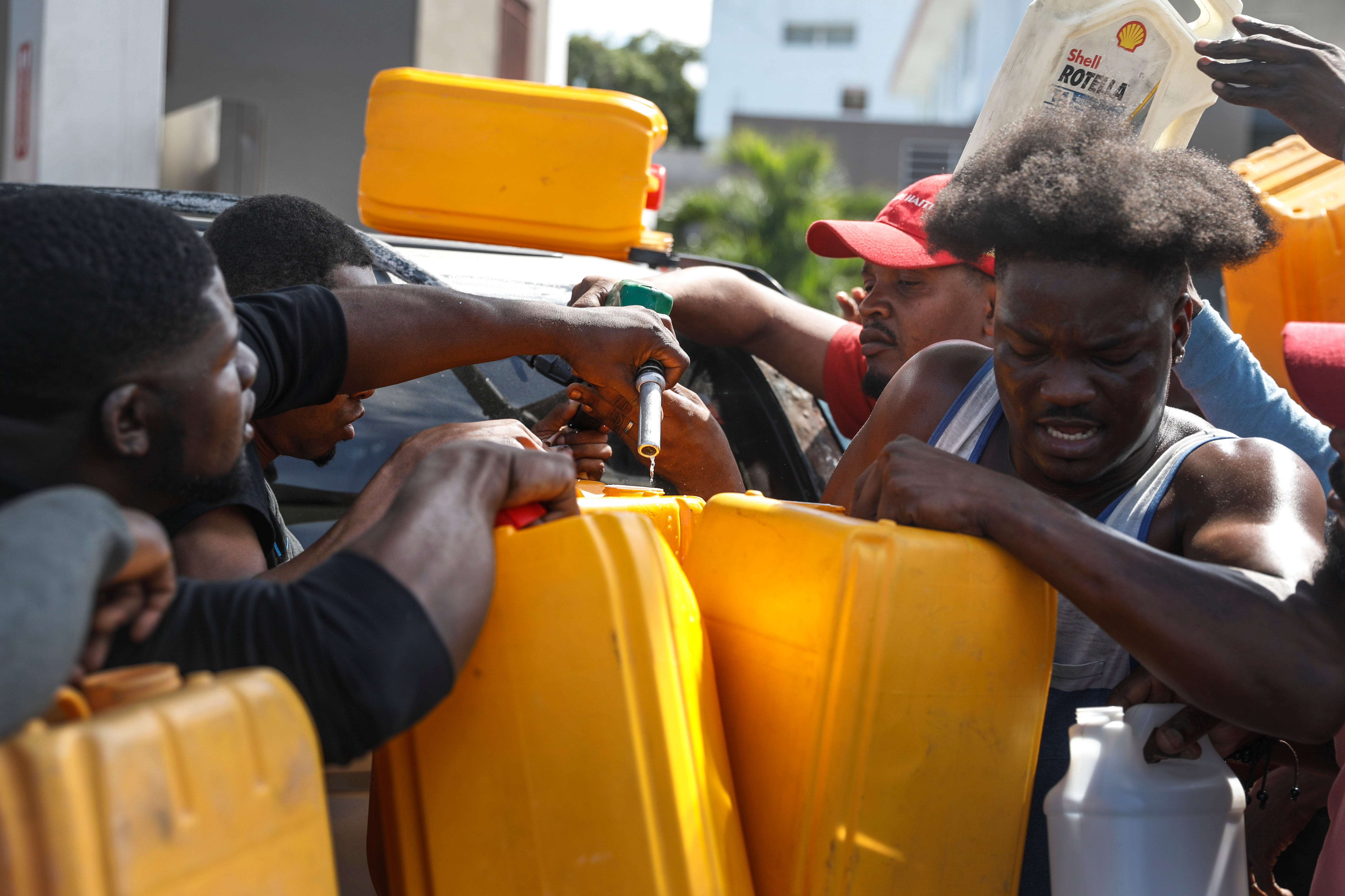 People push and shove as they try to get their gas tanks filled at a gas station in Port-au-Prince, Haiti.