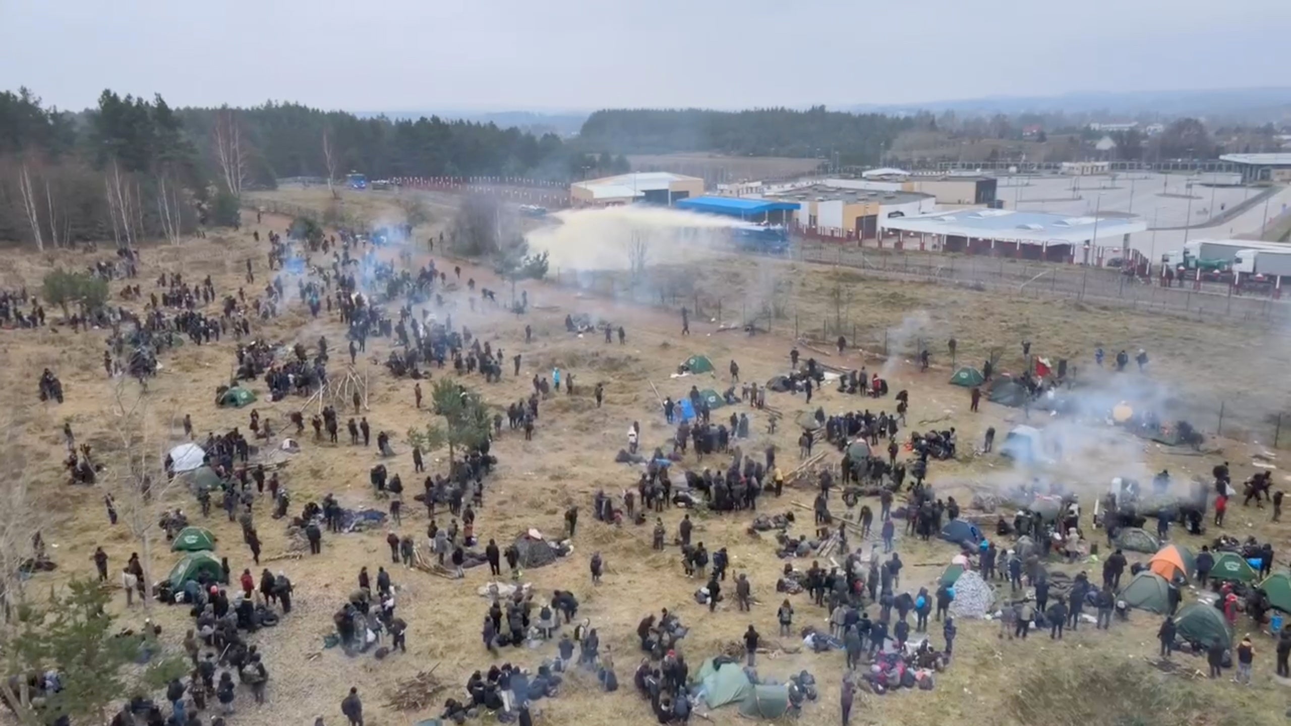 Polish law enforcement officers using a water cannon on migrants