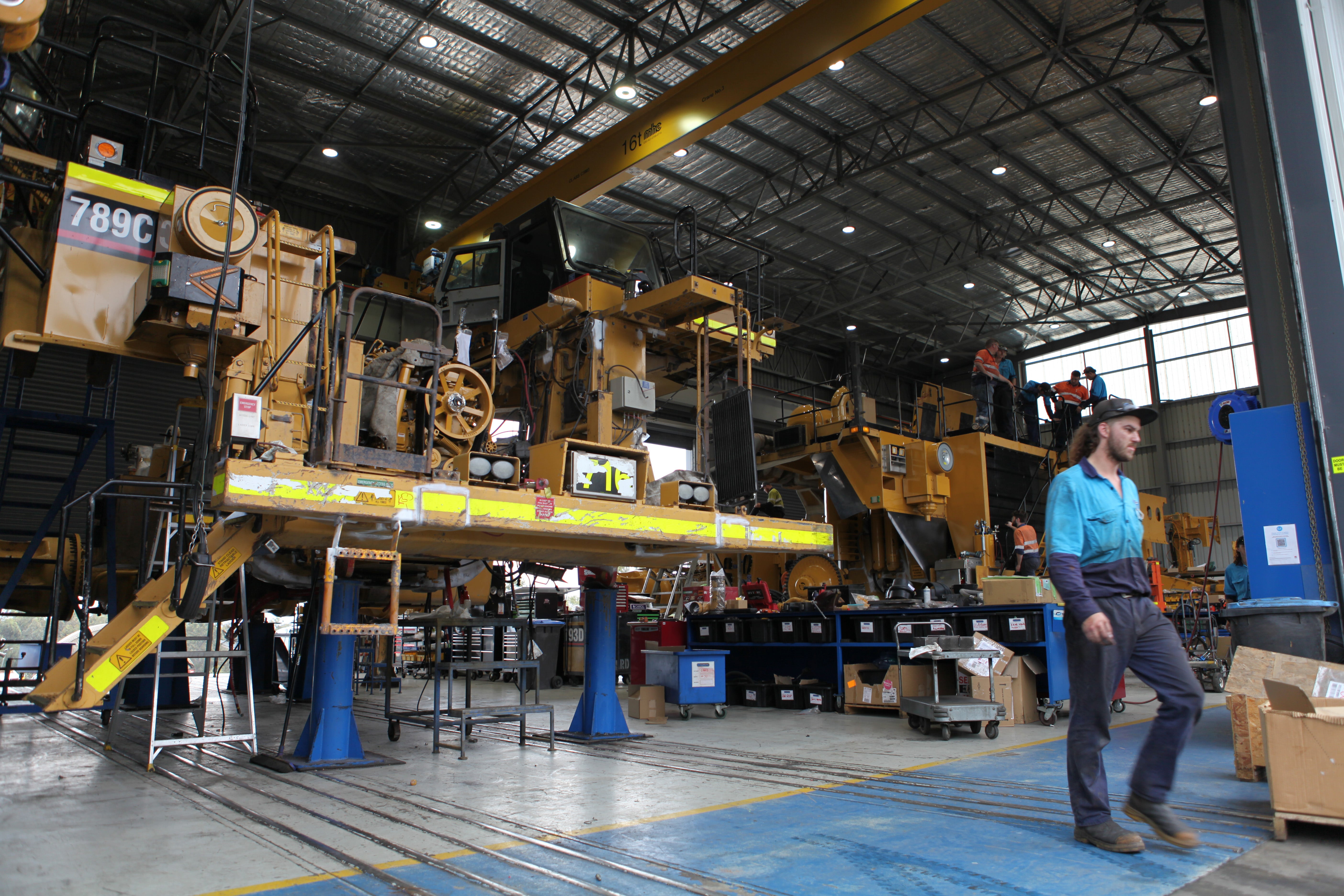 Workers repair giant haul trucks used to transport coal at Complete Parts and Equipment Solutions in Singleton