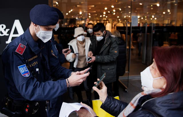 <p>Police officers check the vaccination status of shoppers in Vienna</p>