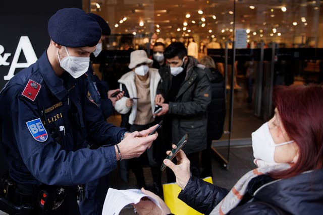<p>Police officers check the vaccination status of shoppers in Vienna</p>