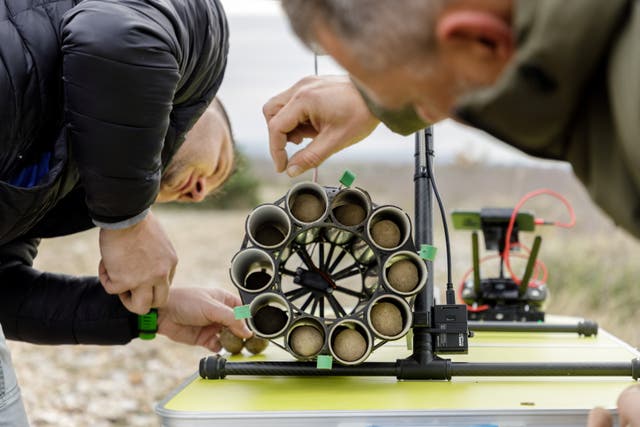 <p>Workers fill a drone with tree seed balls to be scattered in forests in Oklaj</p>