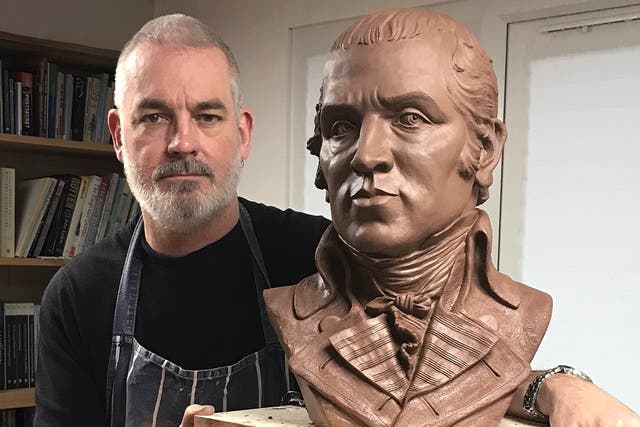 <p>Dave Brown in his studio with the portrait of James Gillray in clay</p>